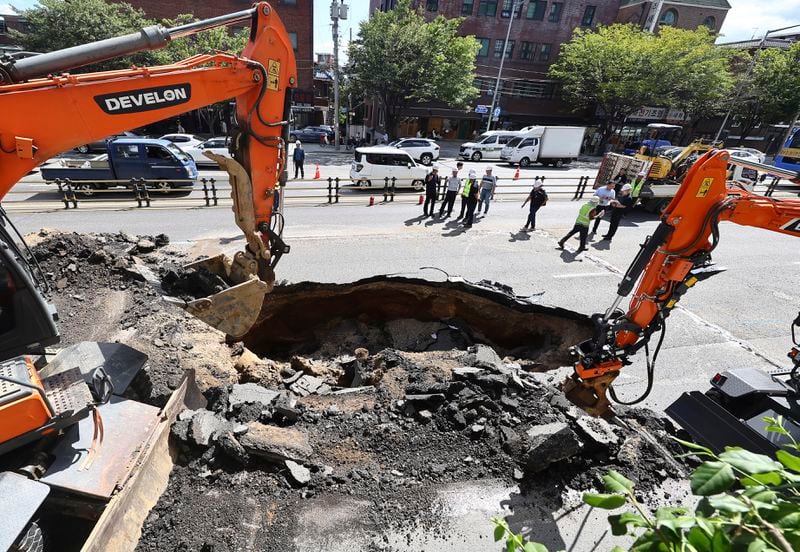 Rescue team work on the street restoration from a sinkhole area on a street in Seoul, South Korea, Thursday, Aug. 29, 2024. (Seo Dae-yeon/Yonhap via AP)