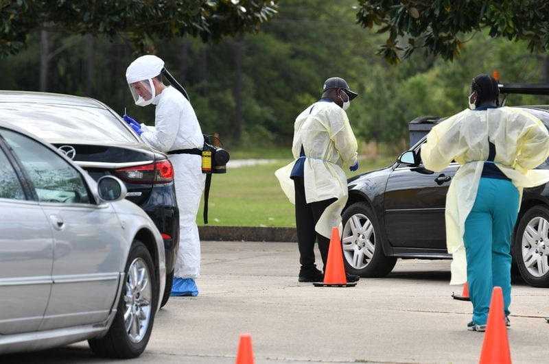 March 24, 2020 Albany - A medical professional in protective equipment (left) collects a sample from a potential COVID-19 patient at a Phoebe Putney Health System drive-through testing site in Albany on Tuesday, March 24, 2020. Well off the interstate some 180 miles south-southwest of Atlanta, Albany's struggles with the Coronavirus stick out like a sore thumb on the state's map, as small towns in the region like Americus and Sylvester reported their first cases of the virus on Friday. (Hyosub Shin / Hyosub.Shin@ajc.com)