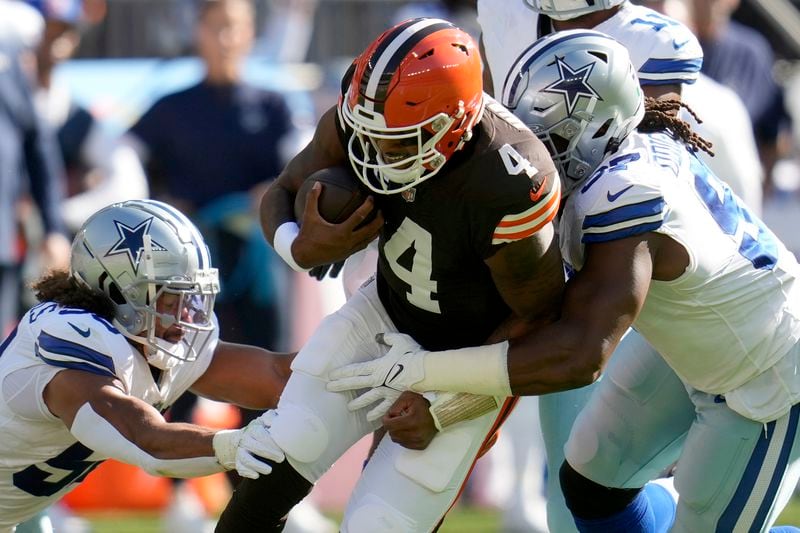 Cleveland Browns quarterback Deshaun Watson (4) is tackled by Dallas Cowboys defensive tackle Osa Odighizuwa, right, and others after a short carry in the first half of an NFL football game in Cleveland, Sunday, Sept. 8, 2024. (AP Photo/Sue Ogrocki)