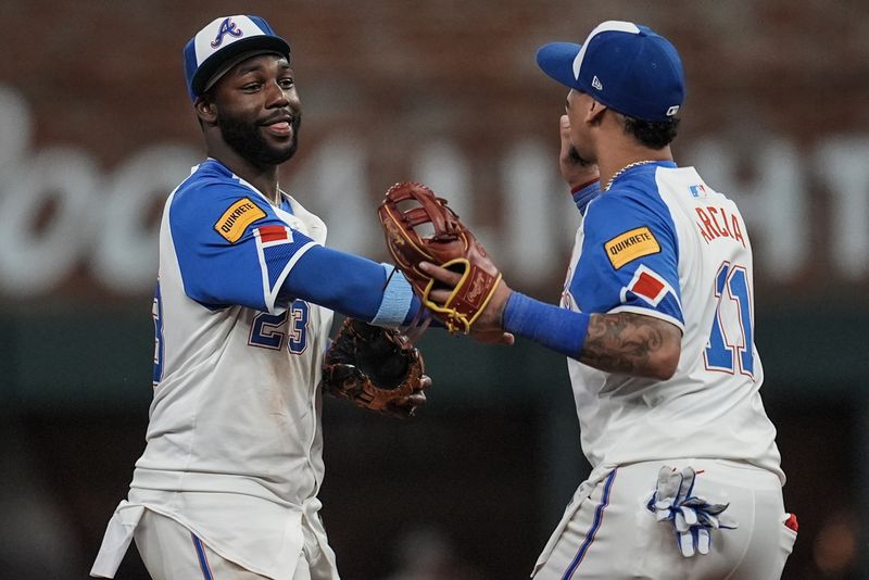 Atlanta Braves' Orlando Arcia (11) Michael Harris II (23) celebrate after a baseball game against the Washington Nationals, Saturday, Aug. 24, 2024, in Atlanta. (AP Photo/Mike Stewart)