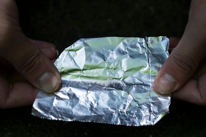 FILE - A homeless person prepares to smoke fentanyl, June 28, 2024, in Portland, Ore. (AP Photo/Jenny Kane, File)