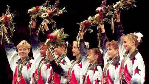 Members of the United States women's gymnastics team - Amanda Borden (from left), Dominique Dawes, Amy Chow, Jaycie Phelps, Dominique Moceanu, Kerri Strug, and Shannon MIller - wave to the crowd after being awarded their gold medals in the team competition of the 1996 Olympic Games Tuesday, July 23, 1996, at the Georgia Dome in Atlanta. (John Gaps III/AP)