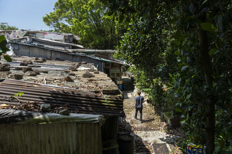 Villager Lo Yuet-ping walks through the Cha Kwo Ling village in east Kowloon, Hong Kong, Sunday, Aug. 25, 2024. (AP Photo/Chan Long Hei)