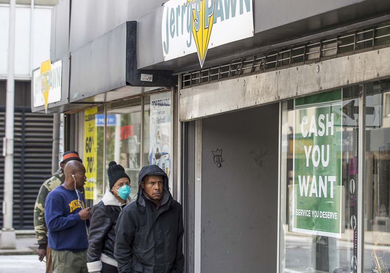 People wait outside Jerry’s Pawn in order to sell or buy items at the downtown Atlanta pawn shop on Wednesday, April 1, 2020. The shop, located on Decatur Street SE, was only allowing two customers in at a time. (ALYSSA POINTER / ALYSSA.POINTER@AJC.COM)