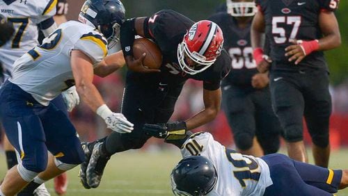 Woodward Academy quarterback Daniel Glover runs for yardage in a 2015 game between Woodward and Marist. The two schools that first met in football in the 1920s will renew their rivalry on Sept. 4.