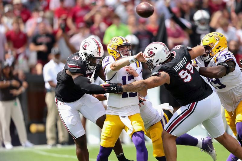 LSU quarterback Garrett Nussmeier (13) gets rid of the ball before South Carolina edge Gilber Edmond (55) and defensive tackle Alex Huntley (95) can sack him during the first half of an NCAA college football game Saturday, Sept. 14, 2024 in Columbia, S.C. (AP Photo/Artie Walker Jr.)