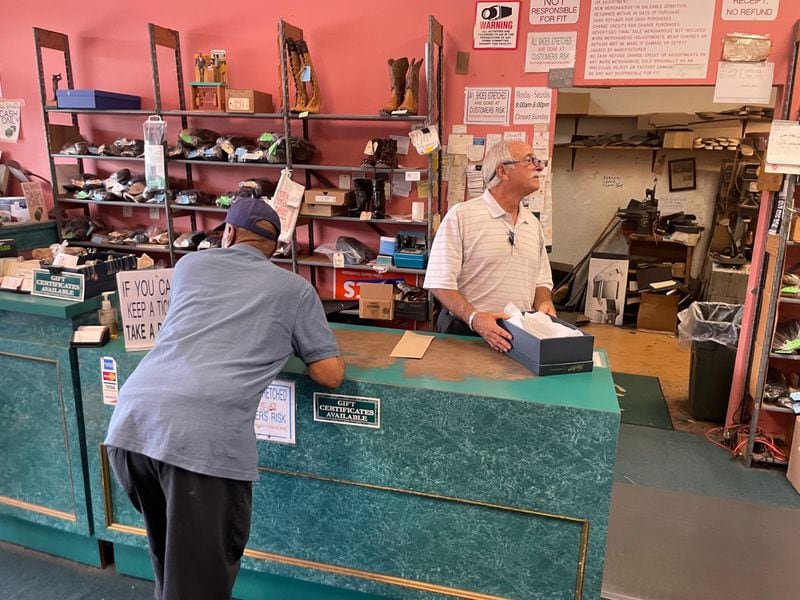 Mark Shemaria, president of Bennie's Shoes, makes a sale as the longtime business gets set to close.