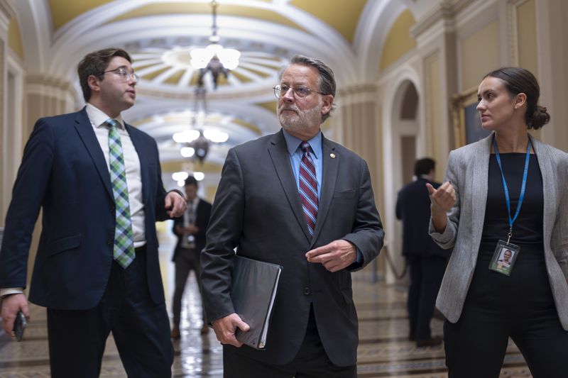 Sen. Gary Peters, D-Mich., left, chairman of the Senate Homeland Security and Governmental Affairs Committee, walks at the Capitol in Washington, Wednesday, Sept. 25, 2024. (AP Photo/J. Scott Applewhite)