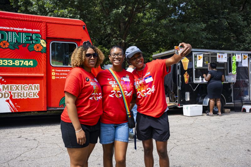 Staff members pose for a selfie at the Pure Heat Community Festival in Piedmont Park on Sunday, Sept. 1, 2024.  (Olivia Bowdoin for the AJC). 