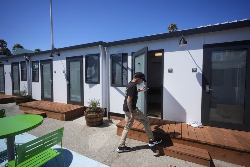 Steven Burcell walks to his room at the Five Keys' Mission Cabins transitional housing location in San Francisco, Monday, Aug. 26, 2024. (AP Photo/Jeff Chiu)