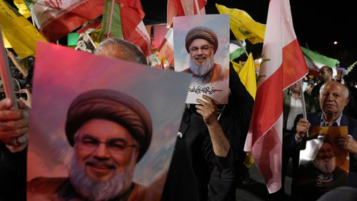 Iranian demonstrators hold posters of slain Hezbollah leader Hassan Nasrallah during an anti-Israeli protest at Felestin (Palestine) Square in Tehran, Iran, Tuesday, Oct. 1, 2024. (AP Photo/Vahid Salemi)