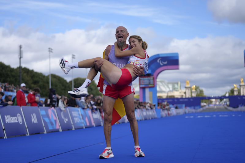 Spain's Elena Congost celebrates on the arms of his guide, after winning the bronze medal in the women's marathon T12 at the 2024 Paralympics, Sunday, Sept. 8, 2024, in Paris, France. (AP Photo/Thibault Camus)