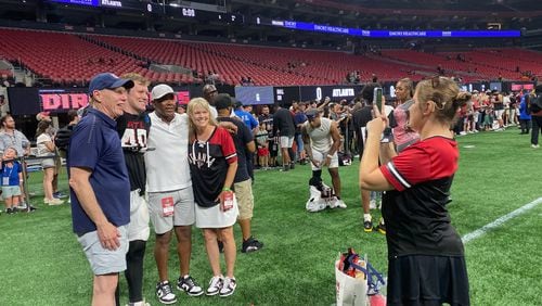 Falcons rookie linebacker J.D. Bertrand poses for a photo following the team's training-camp practice at Mercedes-Benz Stadium August 2, 2024. Bertrand was with his parents Jim (in blue shirt) and Christine (black and red shirt). AJC photo by Ken Sugiura