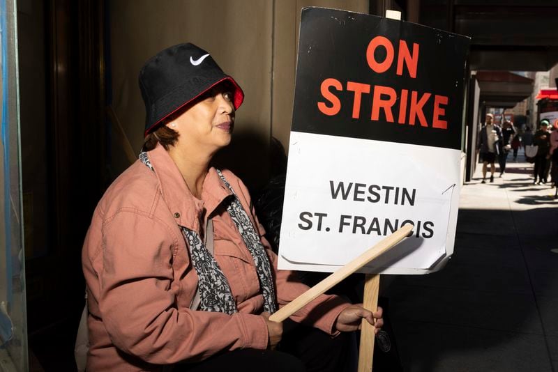 Edralina Lapid holds a sign as hotel workers picket outside the Westin St. Francis Monday, Sept. 2, 2024, in San Francisco. (AP Photo/Benjamin Fanjoy)