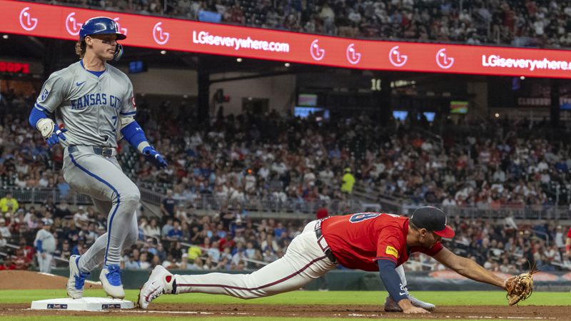 Kansas City Royals' Bobby Witt Jr., left, tags first base before Atlanta Braves first baseman Matt Olson, right, stretches out to field the throw in the third inning of a baseball game, Friday, Sept. 27, 2024, in Atlanta. (AP Photo/Jason Allen)