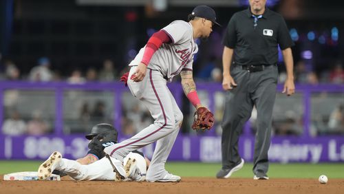 Miami Marlins' Connor Norby (24) slides into second base as Atlanta Braves shortstop Orlando Arcia (11) drops the ball during the fifth inning of a baseball game, Friday, Sept. 20, 2024, in Miami. The Braves lost 4-3. (AP Photo/Marta Lavandier)