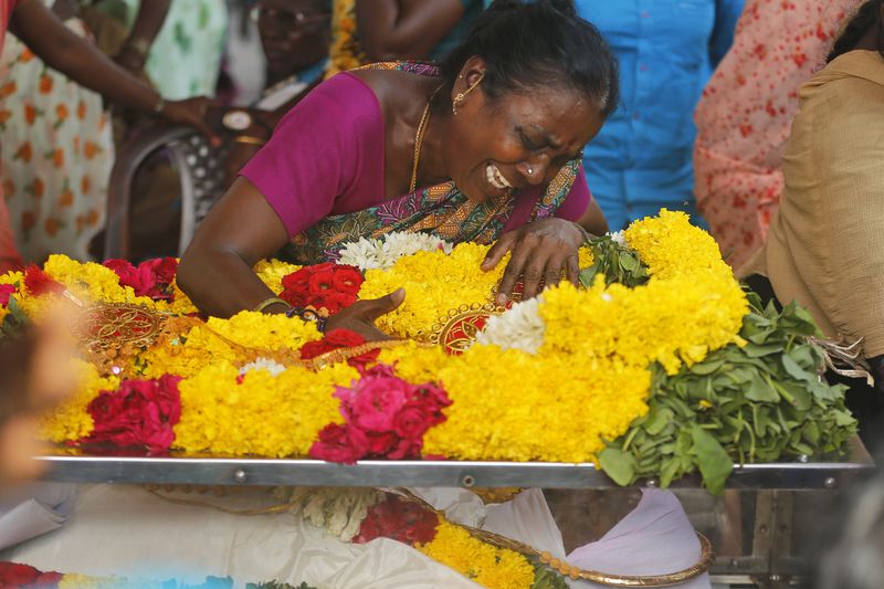 A relative of a man, who died after drinking illegally brewed liquor, cries over a casket containing his body, in Kallakurichi district of the southern Indian state of Tamil Nadu, India, Thursday, June 20, 2024. The state's chief minister M K Stalin said the 34 died after consuming liquor that was tainted with methanol, according to the Press Trust of India news agency. (AP Photo/R. Parthibhan)