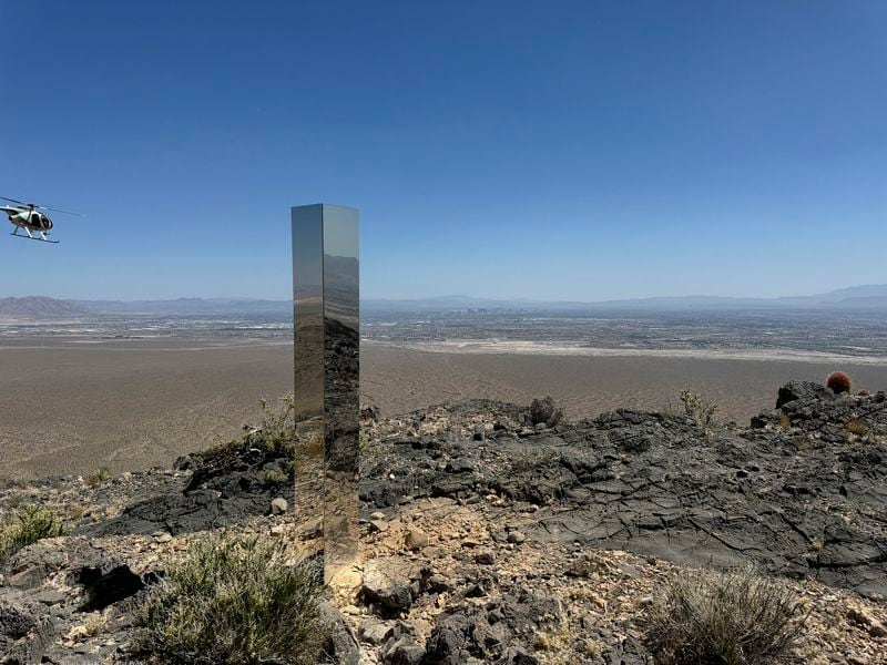 This photo provided by Las Vegas Metropolitan Police Department, the mysterious Monolith is removed on Thursday, June 20, 2024 in Gass Peak, part of the vast Desert National Wildlife Refuge in Nevada. A strange monolith found jutting out of the rocks in a remote mountain range near Las Vegas has been taken down by authorities. (Las Vegas Metropolitan Police Department via AP)