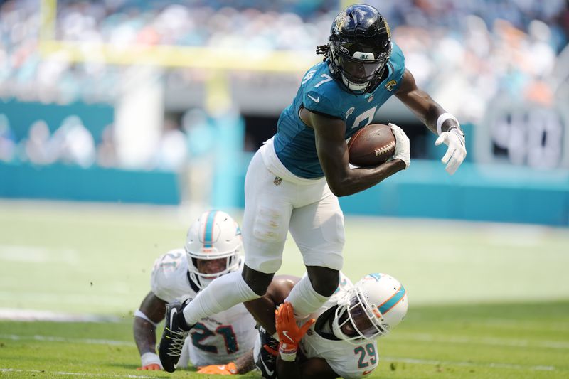 Miami Dolphins cornerback Kendall Fuller (29) grabs Jacksonville Jaguars wide receiver Brian Thomas Jr. (7) during the first half of an NFL football game, Sunday, Sept. 8, 2024, in Miami Gardens, Fla. (AP Photo/Rebecca Blackwell)