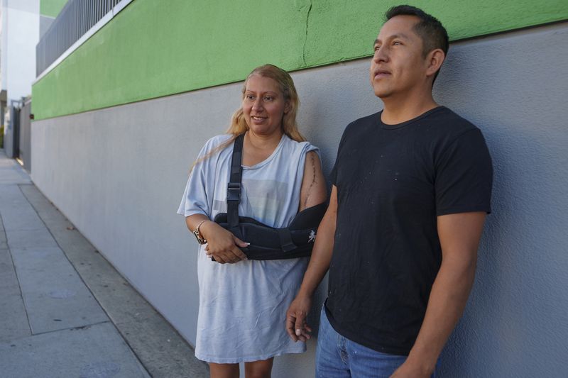 Roberto Garcia and his wife Maria Garcia pause for a picture after dropping their two children off for their first day of school in East Los Angeles on Wednesday, Aug. 14, 2024. (AP Photo/Damian Dovarganes)