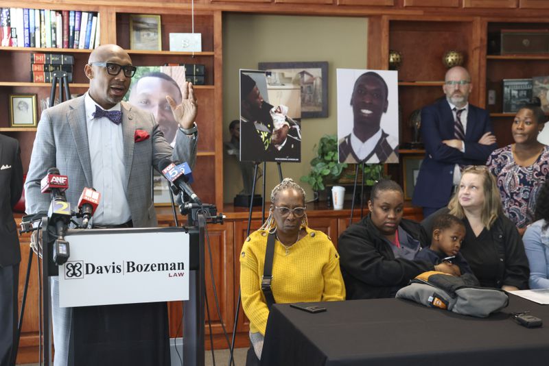 Attorney Mawuli Davis, left, speaks during a press conference about the late Dino Walker in front of his family  at the office of Davis Bozeman Johnson Law, Thursday, September 21, 2023, in Decatur, Ga. Walker was a Fulton inmate who was stabbed to death at the Fulton County Jail in 2022. (Jason Getz / Jason.Getz@ajc.com)