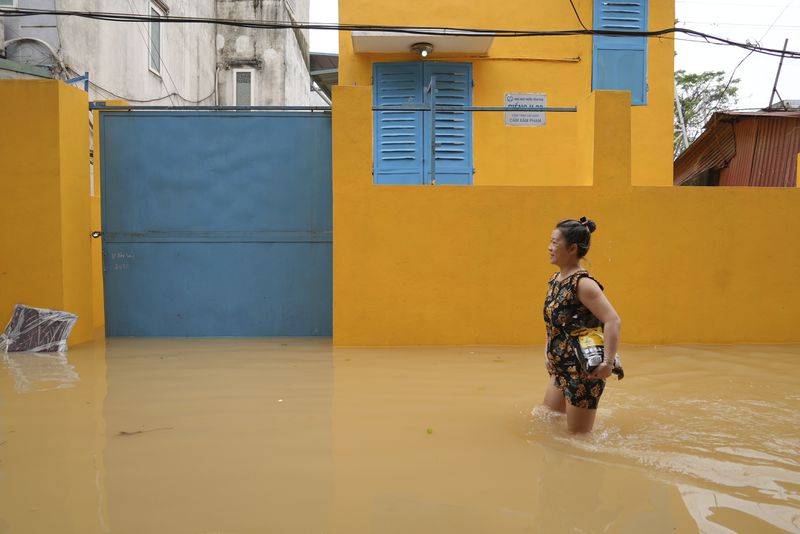 A woman wades in a flooded street in the aftermath of Typhoon Yagi, in Hanoi, Vietnam on Thursday, Sept. 12, 2024. (AP Photo/Hau Dinh)