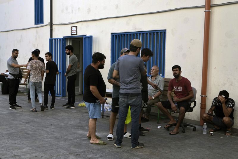 Displaced people sit in a school yard in Beirut, after fleeing the Israeli airstrikes in the south, Thursday, Sept. 26, 2024. (AP Photo/Bilal Hussein)