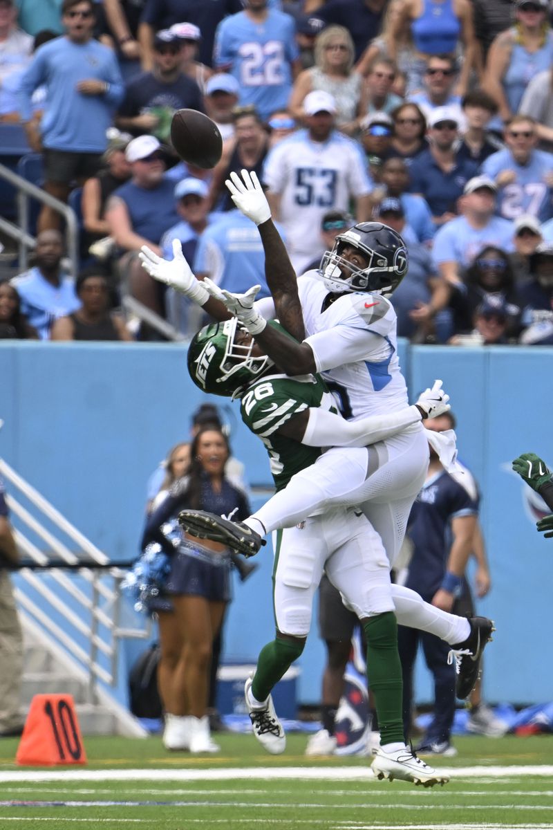 New York Jets cornerback Brandin Echols (26) intercepts the ball from Tennessee Titans wide receiver Treylon Burks (16) in the first half of an NFL football game in Nashville, Tenn., on Sunday, Sept. 15, 2024. (AP Photo/John Amis)