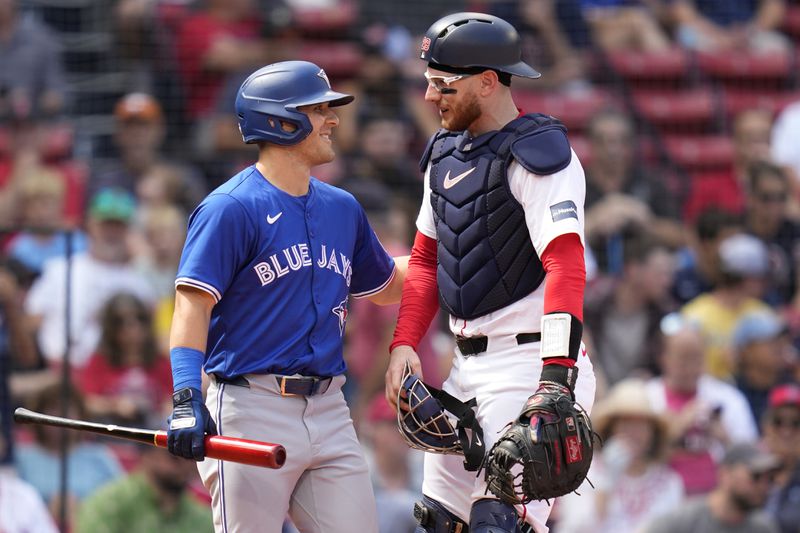 Boston Red Sox catcher Danny Jansen, right, gets a pat on the back from Toronto Blue Jays Daulton Varsho, who pinch-hit for Jansen, during the resumption of the second inning of a baseball game which was delayed due to rain in June, against the Toronto Blue Jays at Fenway Park, Monday, Aug. 26, 2024, in Boston. (AP Photo/Charles Krupa)