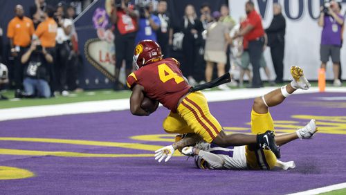 Southern California running back Woody Marks (4) scores the winning touchdown past LSU safety Dashawn Spears (10) during the second half of an NCAA college football game Sunday, Sept. 1, 2024, in Las Vegas. (AP Photo/Steve Marcus)