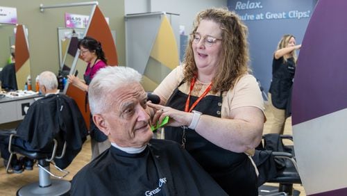 Salon Manager Susan Perdue (right), at Great Clips in Cumming, talks with Richard Herrmann as she cuts his hair. Perdue, who was born deaf, communicates with her clients by reading their lips in the mirror as she stands behind them styling their hair. PHIL SKINNER FOR THE ATLANTA JOURNAL-CONSTITUTION