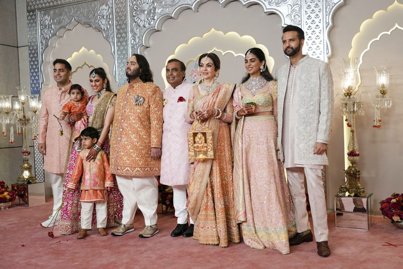 Billionaire Mukesh Ambani, center, poses for a photograph with his family members from L to R, son Akash, daughter-in-law Shloka, son Anant, wife Neeta, daughter Isha and son-in-law Anand Piramal at the wedding of his son Anant Ambani and Radhika Merchant at Jio World Convention Centre in Mumbai, India, Friday, July 12, 2024. (AP Photo /Rajanish Kakade)