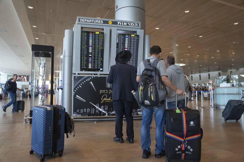 Travelers check departing flights at Ben Gurion International Airport near Tel Aviv, Israel, Monday Sept. 2, 2024. Outgoing flights at the airport were halted for two hours on Monday morning as part of a general strike launched in response to the deaths of hostages held in Gaza. (AP Photo/Ohad Zwigenberg)