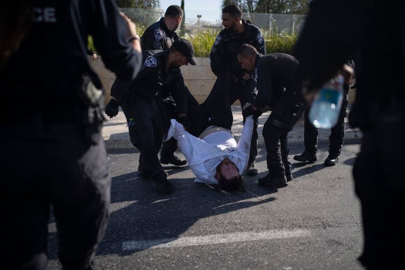 FILE - Israeli police officers remove an ultra-Orthodox Jewish man from the street during a protest against army recruitment in Jerusalem on June 2, 2024. Israel’s Supreme Court on Tuesday, June 25, ruled unanimously that the military must begin drafting ultra-Orthodox men for military service, a decision that could lead to the collapse of Prime Minister Benjamin Netanyahu’s governing coalition as Israel continues to wage war in Gaza. (AP Photo/Leo Correa, File)
