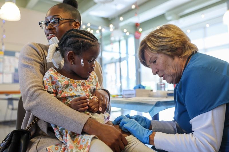 Lourdes Collins, right, administers a vaccine to Dalani Speed, 2, with Serenity Evans during a mobile vaccination clinic called Care-a-Van at Educare Learning Center in West Seattle, Washington, on Aug. 28, 2024. (Kevin Clark/The Seattle Times/TNS)