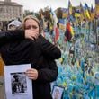 People react during a nationwide minute of silence in memory of fallen soldiers, who defended their homeland in war with Russia, on Defenders Day at the improvised war memorial in Independence square in Kyiv, Ukraine, Tuesday, Oct. 1, 2024. (AP Photo/Efrem Lukatsky)