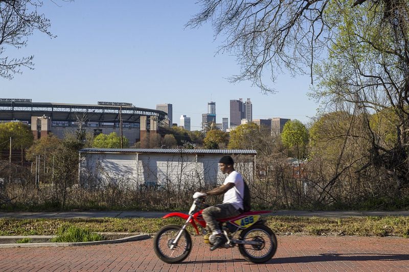 A man rides a dirt bike along brick-lined Atlanta Avenue in the Peoplestown community. 