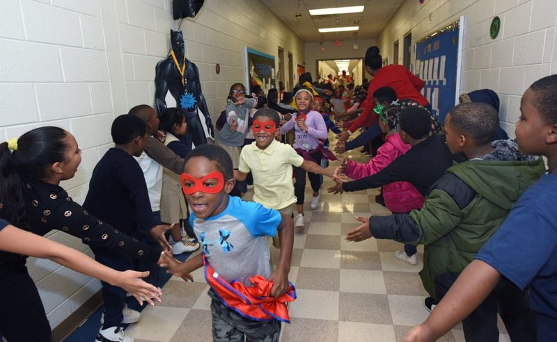 Students participate in the Friday attendance run at Miles Elementary School on Friday, Nov. 22, 2019. That school rewards students with good attendance by holding a run around the hallways, with the students getting to dress up in capes and masks as superheroes. It is one of many strategies Atlanta school leaders are using to improve student attendance rates and combat chronic absenteeism. HYOSUB SHIN / HYOSUB.SHIN@AJC.COM