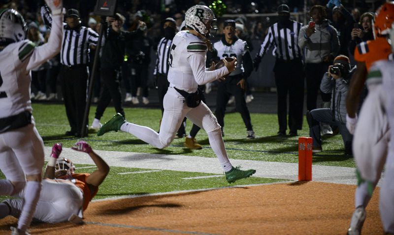 Roswell quarterback Robbie Roper (5) carries the ball into the endzone to score the Hornets' game winning touchdown in the final minutes of the game Friday, Nov. 19, 2021 at North Cobb High School. (Daniel Varnado/ For the Atlanta Journal-Constitution)