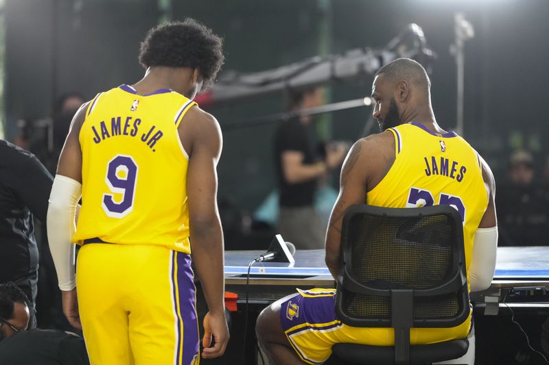 Los Angeles Lakers' LeBron James, right, looks at his son, Bronny James Jr., during the NBA basketball team's media day in El Segundo, Calif., Monday, Sept. 30, 2024. (AP Photo/Jae C. Hong)