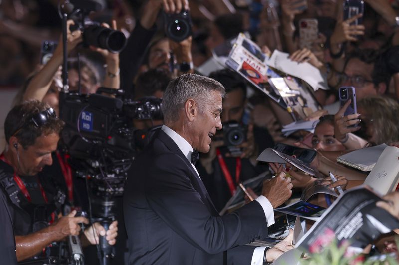 George Clooney signs autographs upon arrival for the premiere of the film 'Wolfs' during the 81st edition of the Venice Film Festival in Venice, Italy, on Sunday, Sept. 1, 2024. (Photo by Vianney Le Caer/Invision/AP)