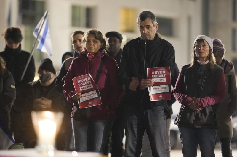 People attend the reading the names of the victims of the Hamas attack on Israel during a commemoration to mark the first anniversary of the attack, at the Brandenburg Gate in Berlin, Germany, Monday, Oct. 7, 2024. (AP Photo/Markus Schreiber)