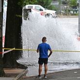 Joe Greene watches a water main break Saturday, June 1, 2024, in Atlanta. City officials were slowly repressuring the city's water system Saturday after corroding water pipes burst in downtown and Midtown, forcing many businesses and attractions to close and affecting water service in area homes. (Hyosub Shin/Atlanta Journal-Constitution via AP)