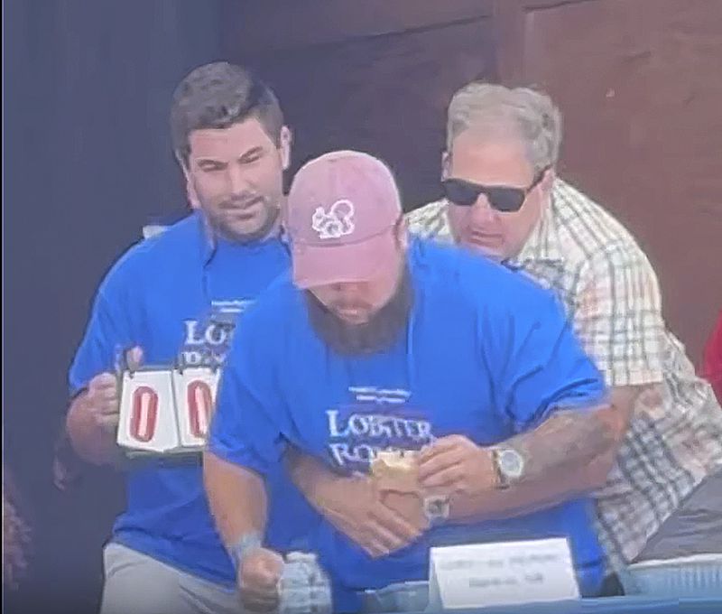 New Hampshire Gov. Chris Sununu uses the Heimlich maneuver on contestant Christian Moreno who is choking at a lobster roll eating contest at the Hampton Beach Seafood Festival in Hampton, N.H., Sunday, Sept. 8, 2024. (AP Photo/Nick Perry)