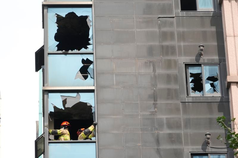 A joint investigation team examines the site of a hotel burnt by Thursday's fire in Bucheon, South Korea, Friday, Aug. 23, 2024. (AP Photo/Ahn Young-joon)