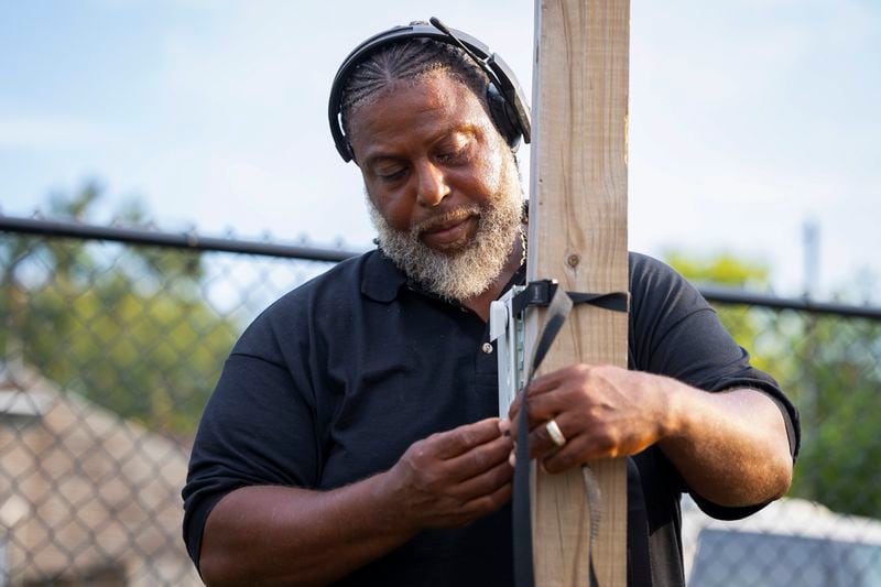 Ricky Johnson attaches an air quality monitor to a pole inside a monitoring site in the Pleasantville area of Houston, Saturday, Aug. 17, 2024. (AP Photo/Annie Mulligan)