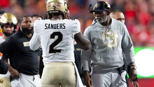 Colorado head coach Deion Sanders, right, talks with quarterback Shedeur Sanders (2) on the sideline between plays against Nebraska during the second half of an NCAA college football game Saturday, Sept. 7, 2024, in Lincoln, Neb. (AP Photo/Rebecca S. Gratz)