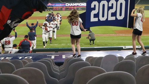 Cutout fans and two cheerleaders holding the 2020 pennant are the only ones looking on as the Atlanta Braves celebrate clinching their third consecutive National League East championship title with a 11-1 victory over the Miami Marlins Tuesday, Sept. 22, 2020, in Atlanta. (Curtis Compton / Curtis.Compton@ajc.com)