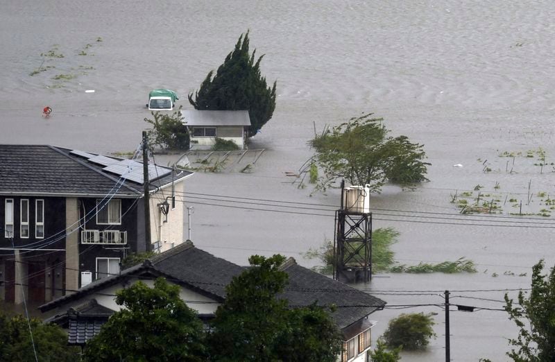 Farmland along a river is flooded by heavy rains caused by a typhoon in Yufu, Oita prefecture, western Japan, Thursday, Aug. 29, 2024. (Kyodo News via AP)