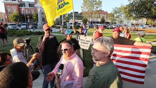 Chris Hill, commanding officer of the III% Georgia Security Force, speaks to the news media during a 2016 protest against building a mosque in Newton County. CURTIS COMPTON/CCOMPTON@AJC.COM